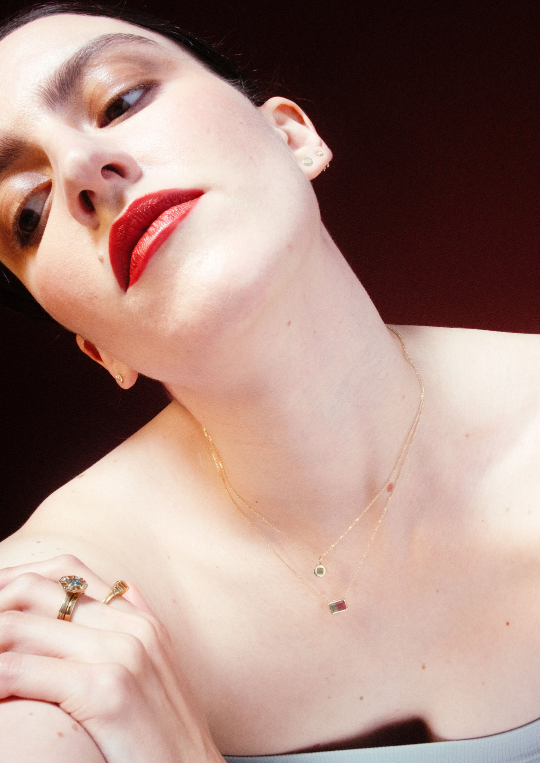 woman wearing multiple necklaces by genevieve schwartz and wearing bright red lipstick