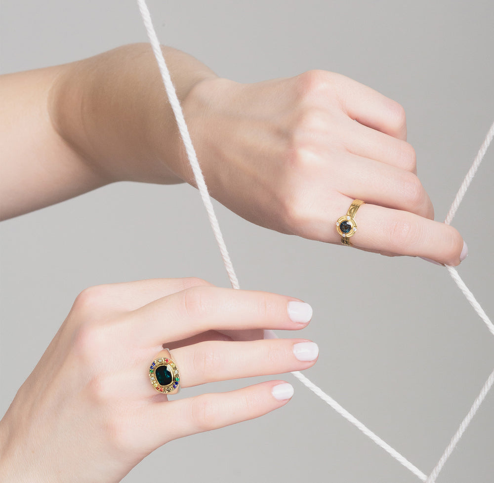 sunray signet ring and varsity ring worn on two hands holding white strings