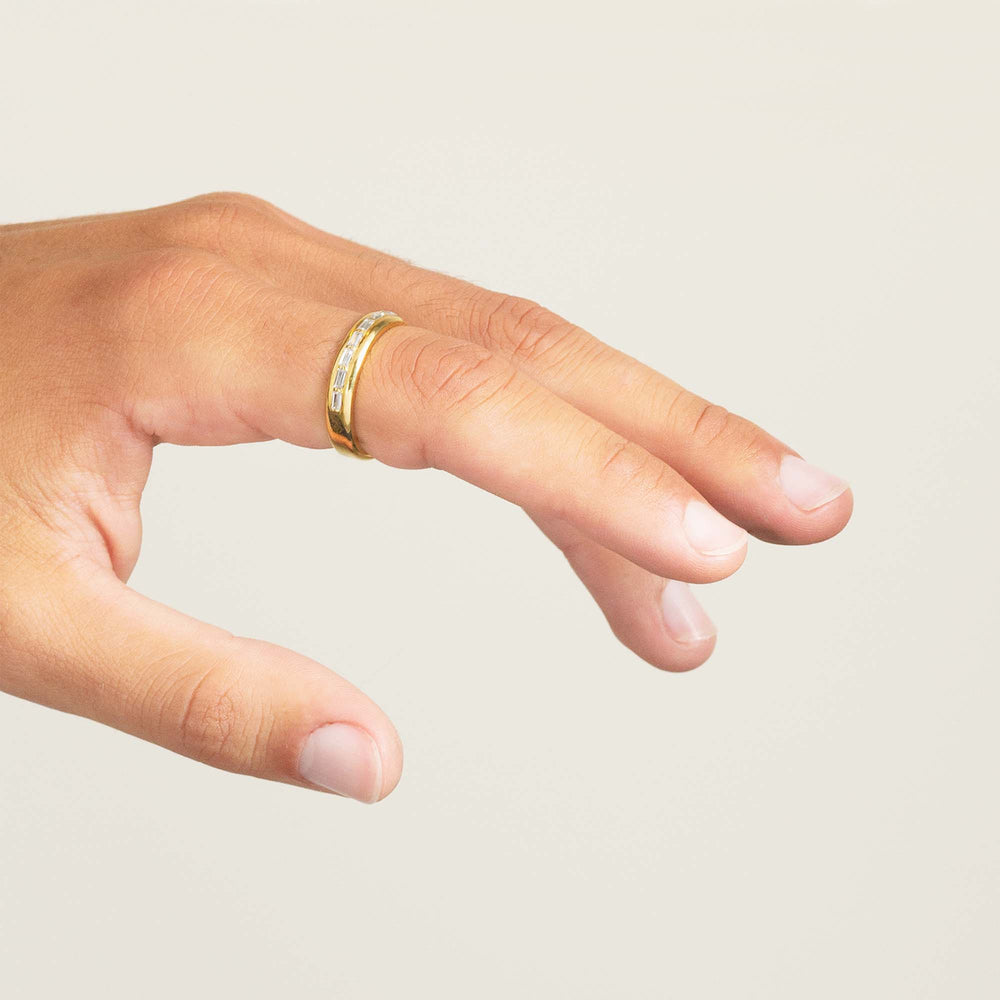 mans hand wearing mens engagement ring set with baguette cut diamonds