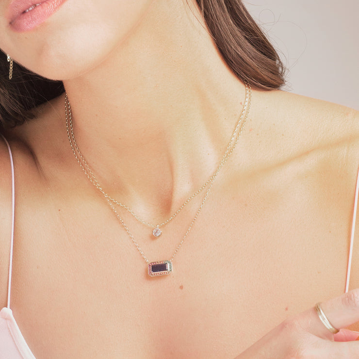 close up of solitaire pendant on a woman alongside refract pendant